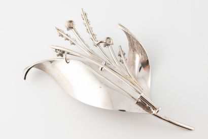 null Delicate brooch with flowering branches in platinum, formed by chased leaves...