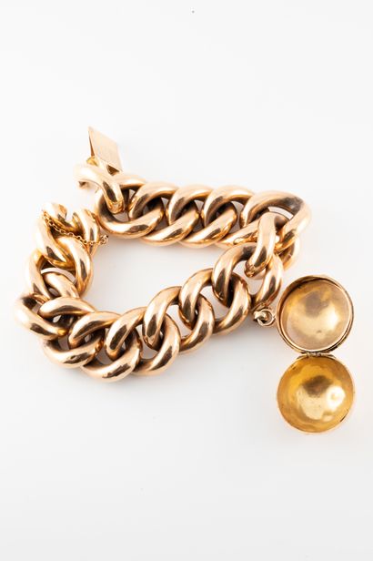 null 18k yellow gold supple bracelet with large curb chain holding a spherical 18k...