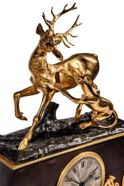 null Pendule en bronze doré surmontée d’un cerf attaqué par un chien en bronze à...