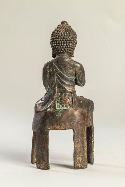 Arts d'Asie Buddha vêtu d'une robe monastique assis en méditation sur un haut socle...