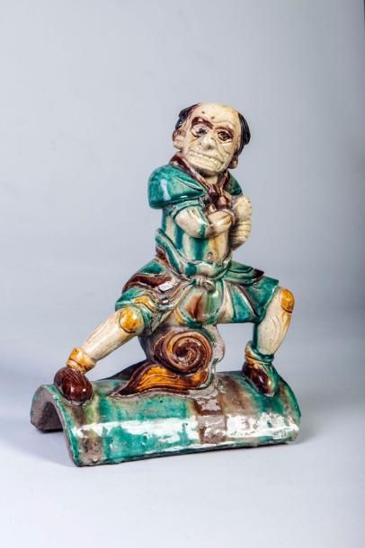 Arts d'Asie Tuile faîtière surmontée d'un personnage grotesque en céramique vernissée...
