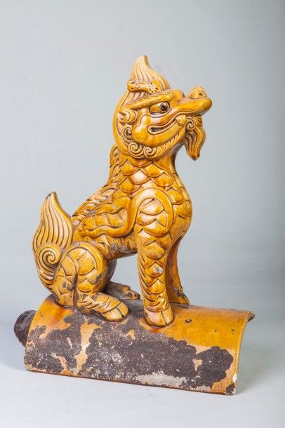 Arts d'Asie Tuile faîtière surmontée d'une chimère Kilin. Céramique vernissée jaune....