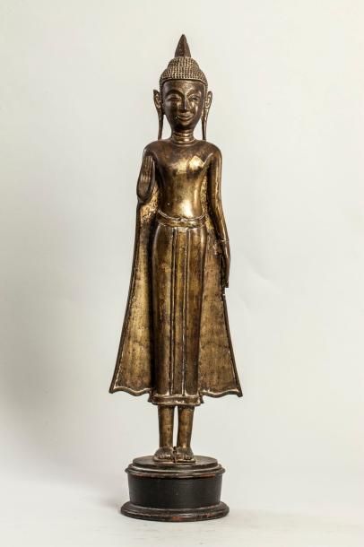 Arts d'Asie Buddha debout déployant les pans de sa robe monastique, la main droite...