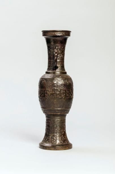 Arts d'Asie Vase balustre à anses zoomorphes moulé d'un décor archaïsant. Bronze....