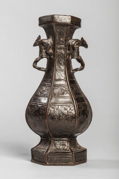 Arts d'Asie Vase à corps hexagonal moulé d'un décor archaïsant et serti de deux anses...