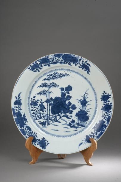 Arts d'Asie Plat en porcelaine blanche décoré en bleu cobalt sous couverte d'un bosquet...