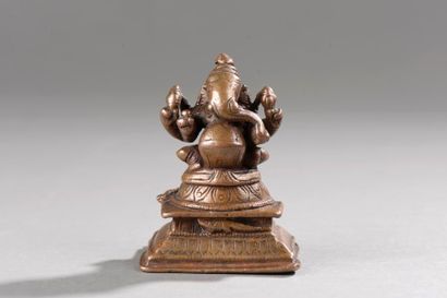 null Ganesh assis en lalitasana sur un socle étagé, sous une forme à quatre bras...