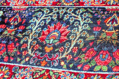 null Tapis ancien en laine et coton sur fond rouge brique, Beloutch, début XXe.