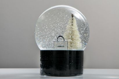 null CHANEL.Boule à neige à décor de sapin de Noël au pied duquel se trouve de multiples...
