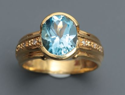 null Bague en or jaune, 750 MM, ornée d'une topaze bleue épaulée de diamants, taille...