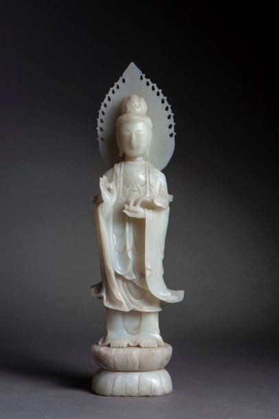 null Le Boddhisattva Kwan Yin debout sur un socle lotiforme coiffé d'un haut chignon...