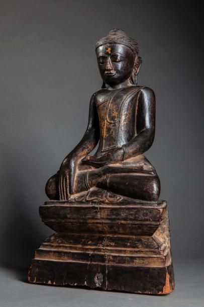 null Buddha Maravijaya assis sur un socle étagé vêtu de la robe monastique, une main...