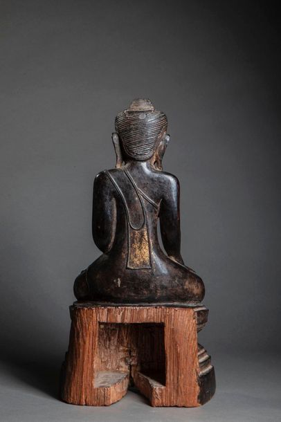 null Buddha Maravijaya assis sur un socle étagé vêtu de la robe monastique, une main...