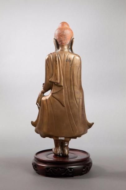 null Buddha debout en posture hiératique déployant les pans de sa robe monastique...