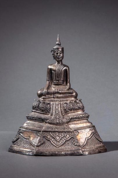 null Buddha Maravijaya votif sur un haut socle étagé à frise lotiforme. Argent repoussé...