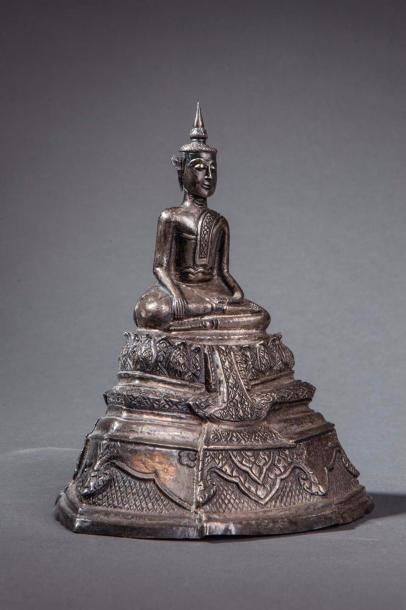 null Buddha Maravijaya votif sur un haut socle étagé à frise lotiforme. Argent repoussé...
