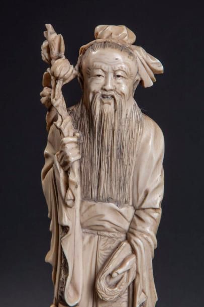  Sage Taoïste debout vêtu d'une longue tunique coiffé d'un foulard retenant sa longue...
