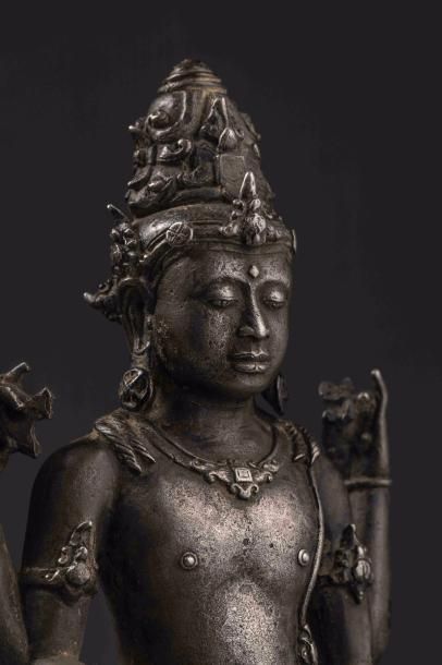 null Vishnu debout dans une posture hiératique, sous une forme à quatre bras tenant...