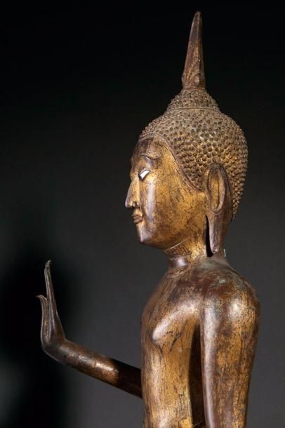 null Buddha debout sur un piédestal circulaire étagé dans une posture hiératique...