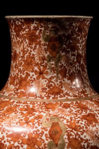 null Vase balustre en porcelaine décoré d'un semi floral parsemé d'enfants bouddhiques...