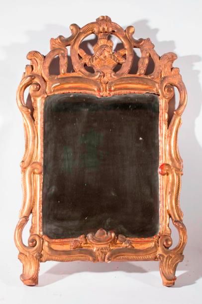 null Petit miroir ajouré de forme mouvementée à fronton, en bois sculpté et doré...