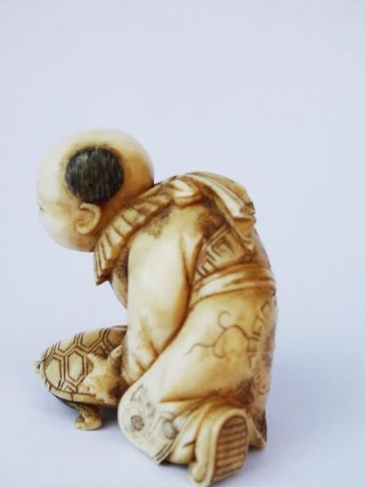 null Netsuké en ivoire représentant un enfant tenant une tortue - JAPON - XIXème...