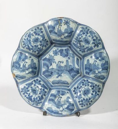 null DELFT - Plat polylobé en faience décoré en caimaieu bleu de scènes chinoises...