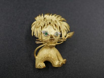 null Broche "Lion" en or jaune guilloché , yeux ornés d'une émeraude regaussée de...