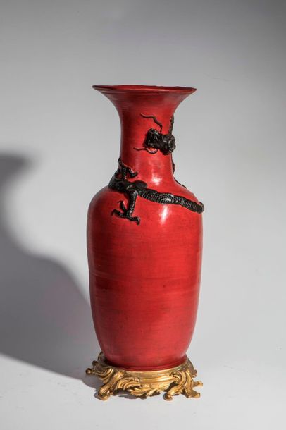 null Vase en porcelaine à fond de laque rouge orné d'un dragon noir en relief à monture...