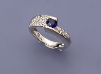 null Bague en or gris, 750 MM, centrée d'une pierre bleue épaulée de deux pavages...