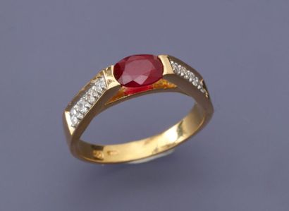 null Bague en or jaune, 750 MM, centrée d'un rubis ovale entre deux chutes de huit...