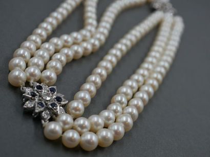 null Collier à triple rangs de perles retenu par deux motifs de fleurs en or blanc...