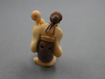 null Okimono en ivoire représentant un vieillard faisant sortir un kilin de son pot...