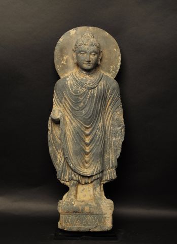 null Bouddha auréolé en grès gris sur socle lotiforme, il porte un antaravasaka,...