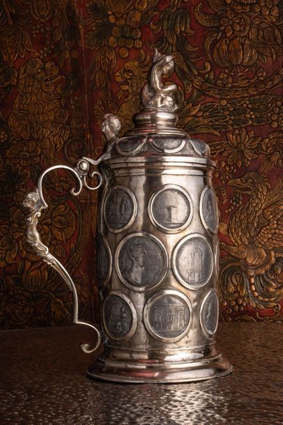 null Grande chope (ou tankard) commémoratif en métal argenté orné de nombreuses médailles,...