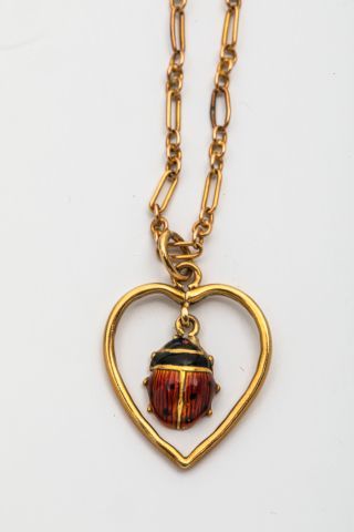 null Collier pendentif en or jaune 18k motif "cœur" retenant en pampille une coccinnelle...