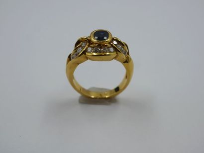 null Bague en or jaune 18k ornée d'un saphir taille ovale dans un entourage de frises...