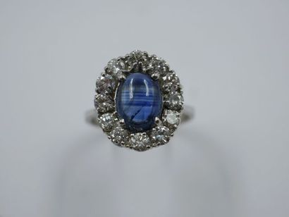 null Bague jupe en or gris 18k ornée d'un cabochon de saphir dans un entourage de...