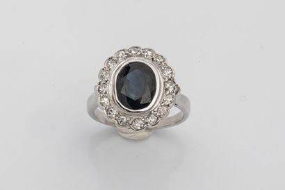 null Bague marguerite en or gris 18k ornée d'un saphir ovale dans un entourage de...