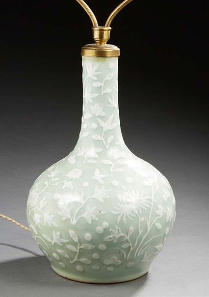 CHINE 
Vase bouteille en porcelaine à fond vert céladon décoré en léger relief en...