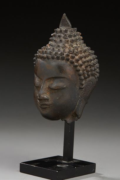 THAÏLANDE 
Tête de bouddha en bronze à patine brune, la tête coiffée en son sommet...