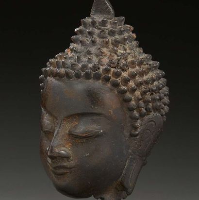 THAÏLANDE 
Tête de bouddha en bronze à patine brune, la tête coiffée en son sommet...