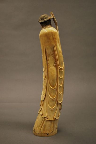 JAPON 
Grande figurine en ivoire sculpté représentant un homme tenant d'une main...