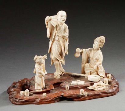 JAPON 
Okimono en ivoire sculpté composé d'un groupe de trois personnages sur un...