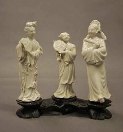 CHINE 
Ensemble de trois statuettes en porcelaine blanche sur un même socle.
