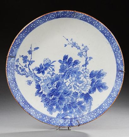 JAPON 
Grand plat circulaire en porcelaine décoré en bleu de branches fleuries.
Début...