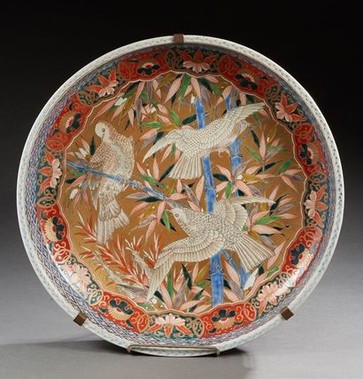 JAPON 
Grand plat creux circulaire en porcelaine décoré dans la palette Imari d'oiseaux...