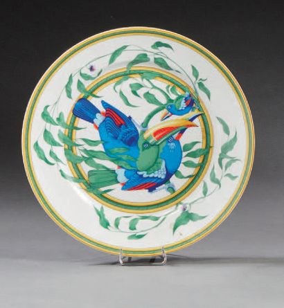 HERMES «Toucans» 
Assiette en porcelaine émaillée polychrome à décor de deux toucans...