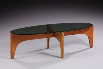 TRAVAIL DES ANNÉES 1960 
Table basse de forme ovale, plateau en verre fumé reposant...