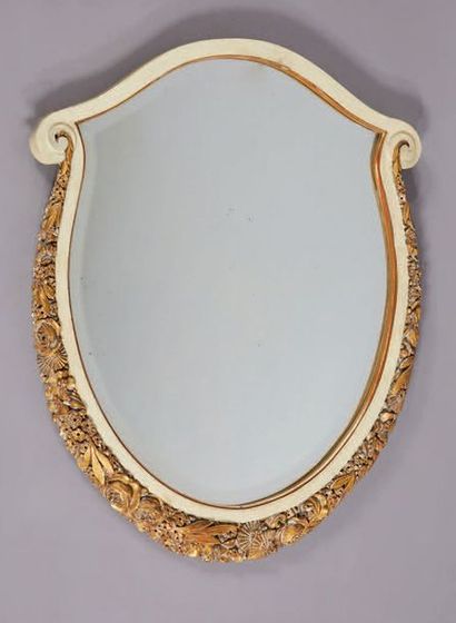 Maurice DUFRENE (1876-1958) 
Miroir en bois sculpté laqué crème et doré à décor de...